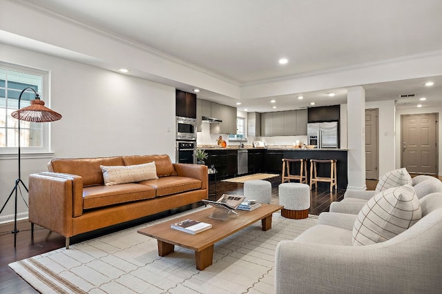 living room with recessed lighting, light wood finished floors, visible vents, crown molding, and baseboards