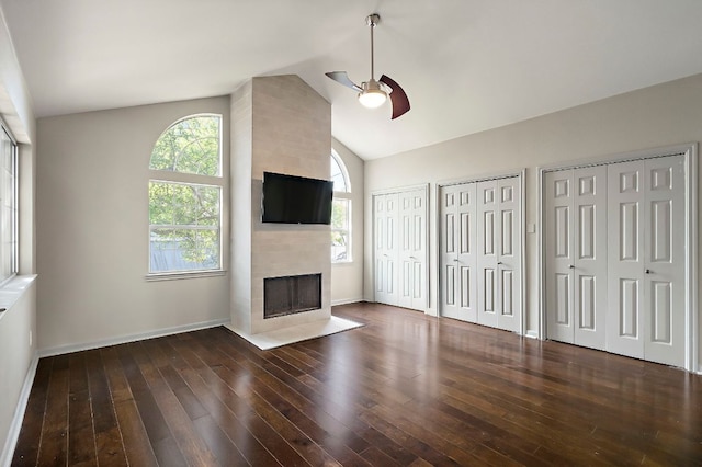 unfurnished living room with baseboards, a ceiling fan, hardwood / wood-style floors, lofted ceiling, and a tile fireplace