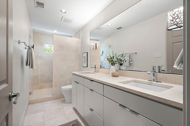 bathroom with toilet, a stall shower, a sink, and visible vents