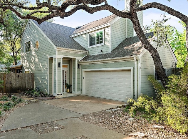 traditional home with a chimney, driveway, fence, and a shingled roof