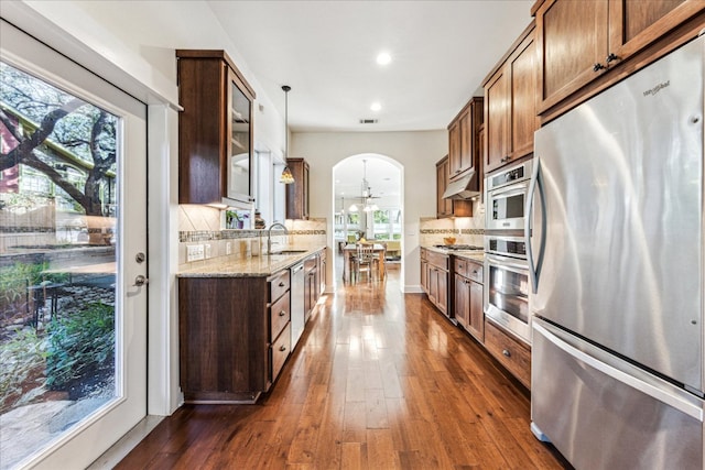 1008 W Monroe St W, Austin, TX 78704 - kitchen featuring stainless steel appliances, a sink, arched walkways, dark wood-style floors, and healthy amount of natural light