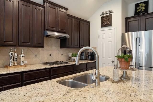 kitchen featuring a sink, decorative backsplash, under cabinet range hood, and stainless steel appliances