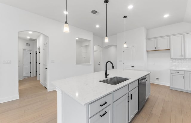 6517 Apache Plum Ln, Spicewood, TX 78669 - kitchen featuring arched walkways, light wood-style flooring, hanging light fixtures, and recessed lighting