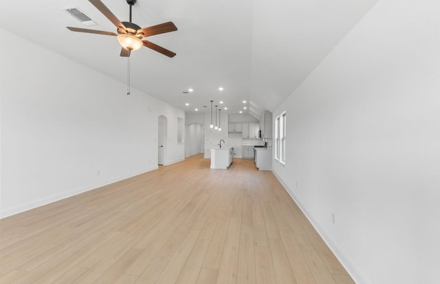 6517 Apache Plum Ln, Spicewood, TX 78669 - unfurnished living room featuring ceiling fan, lofted ceiling, recessed lighting, arched walkways, and light wood finished floors