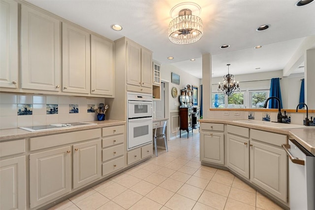 1101 Lakeway Dr Unit D, Lakeway, TX 78734 - kitchen with a chandelier, black electric stovetop, dishwasher, white double oven, and light countertops