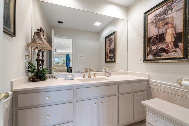 1101 Lakeway Dr Unit D, Lakeway, TX 78734 - bathroom with vanity, wainscoting, tile walls, and a textured wall