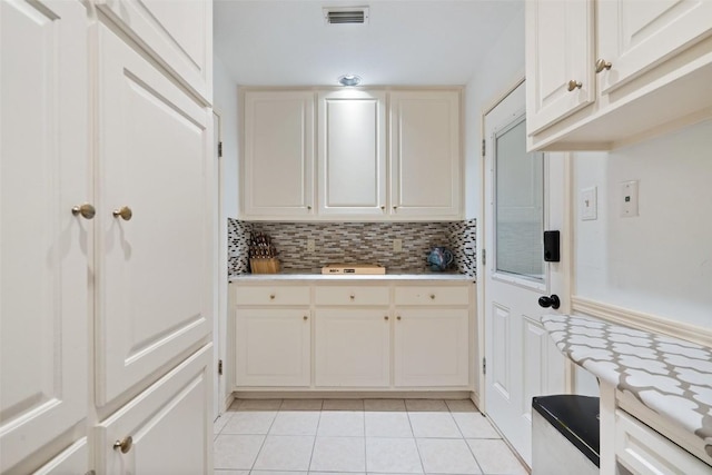 1101 Lakeway Dr Unit D, Lakeway, TX 78734 - kitchen with light tile patterned floors, decorative backsplash, light countertops, and white cabinets