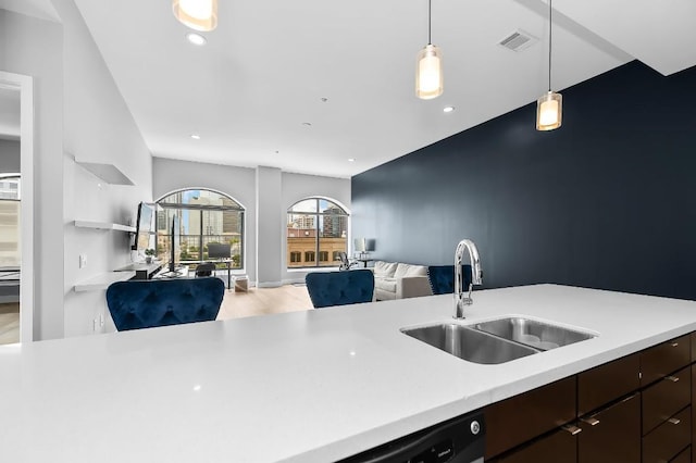 507 Sabine St Unit 505, Austin, TX 78701 - kitchen with open floor plan, light countertops, dark brown cabinetry, decorative light fixtures, and recessed lighting