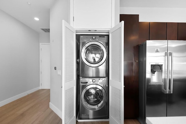 507 Sabine St Unit 505, Austin, TX 78701 - washroom with estacked washer and dryer, wood finished floors, and recessed lighting