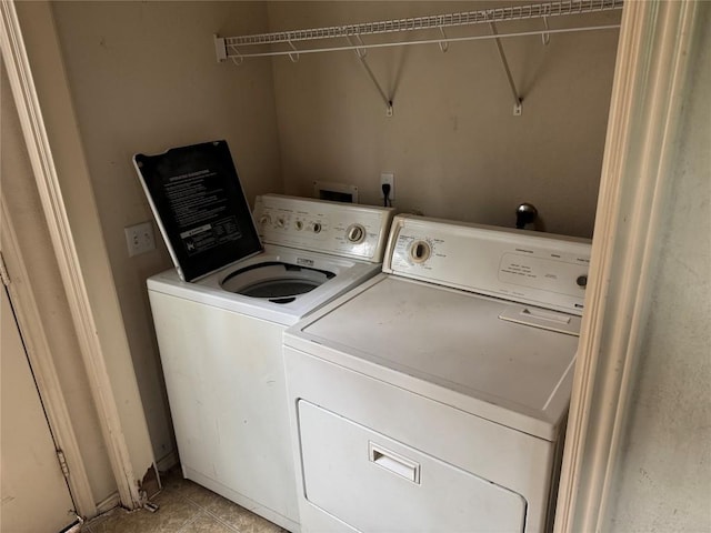 laundry area with independent washer and dryer, laundry area, and light tile patterned floors