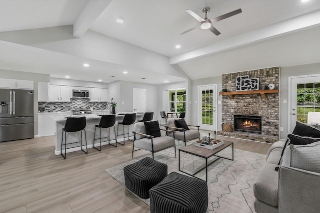 living room featuring recessed lighting, light wood-style flooring, vaulted ceiling with beams, and a ceiling fan