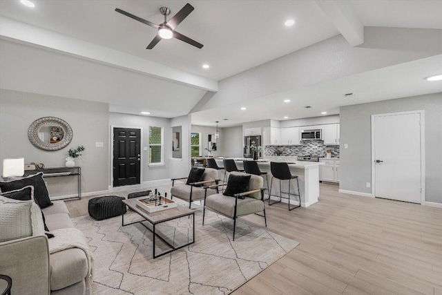 living area featuring recessed lighting, light wood-style flooring, a ceiling fan, and lofted ceiling with beams