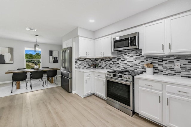kitchen featuring white cabinets, visible vents, light countertops, and appliances with stainless steel finishes