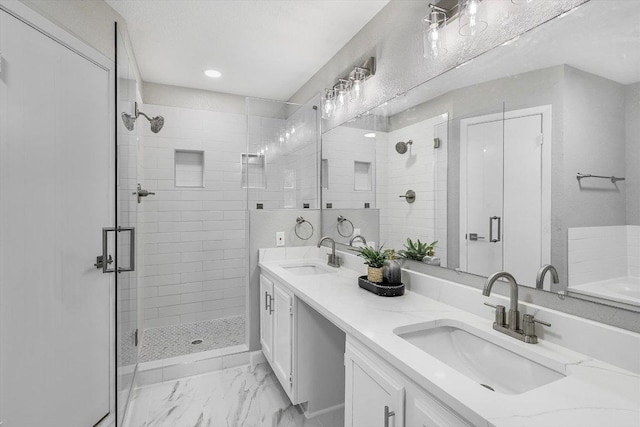 bathroom with a sink, a shower stall, marble finish floor, and double vanity