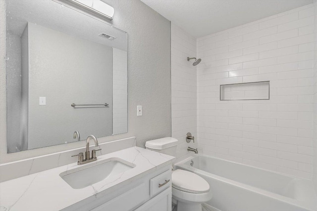 full bath featuring visible vents, washtub / shower combination, toilet, a textured wall, and vanity