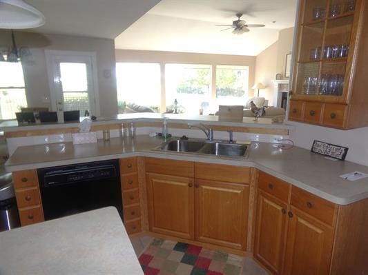 kitchen featuring light countertops, black dishwasher, a healthy amount of sunlight, and a sink