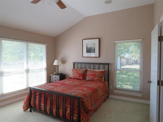 bedroom with carpet floors, multiple windows, and vaulted ceiling