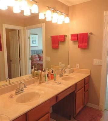 bathroom with double vanity, ensuite bath, and a sink
