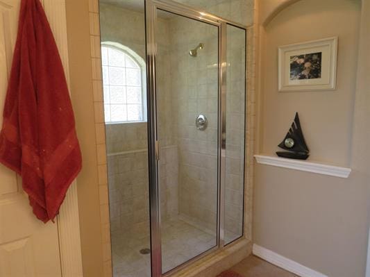full bathroom featuring baseboards and a stall shower