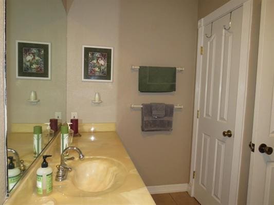 bathroom featuring tile patterned floors, vanity, and baseboards
