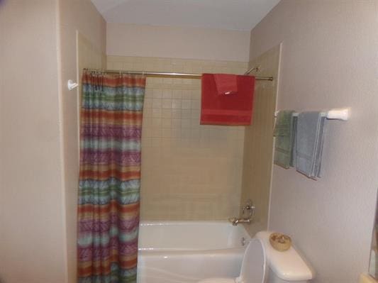 bathroom featuring shower / tub combo and toilet