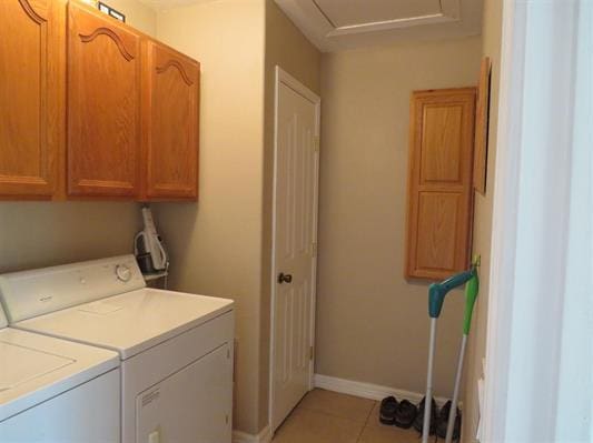 laundry area featuring independent washer and dryer, light tile patterned floors, baseboards, and cabinet space