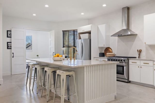 1018 Harwood Pl, Austin, TX 78704 - kitchen featuring wall chimney range hood, high end range, freestanding refrigerator, finished concrete floors, and a kitchen island