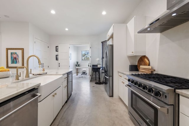kitchen with a sink, wall chimney range hood, white cabinetry, stainless steel appliances, and finished concrete floors