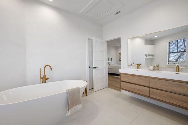 ensuite bathroom with ensuite bathroom, visible vents, a freestanding tub, double vanity, and tile patterned flooring
