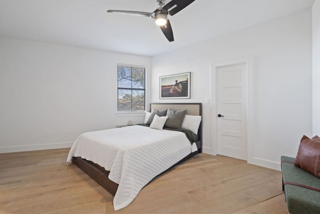 bedroom with light wood-style flooring, baseboards, and a ceiling fan