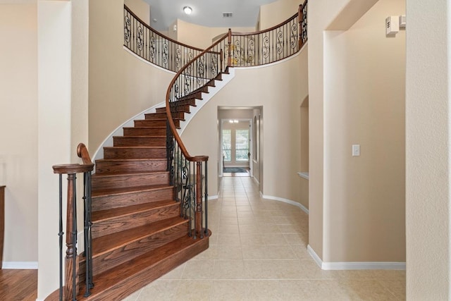 staircase with baseboards, tile patterned flooring, and visible vents
