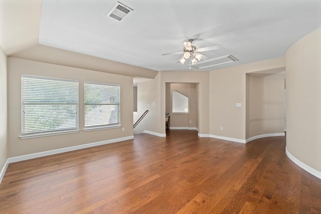 empty room with visible vents, ceiling fan, wood finished floors, and baseboards