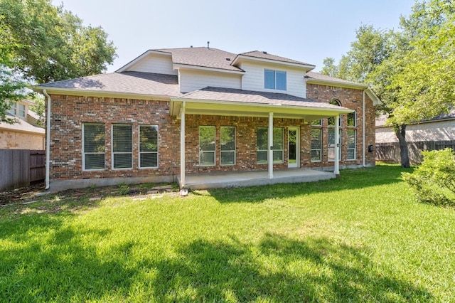 back of house featuring a yard, brick siding, fence private yard, and a patio area