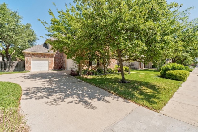 obstructed view of property with a garage, fence, brick siding, a front lawn, and driveway