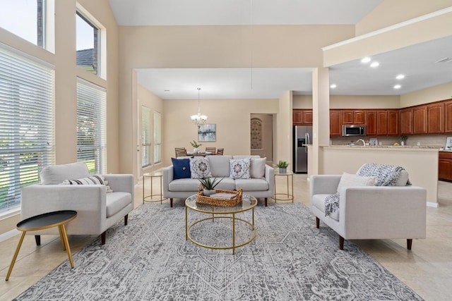 living room with a high ceiling, an inviting chandelier, and light tile patterned flooring