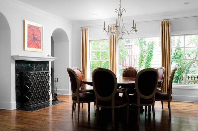 dining room with arched walkways, plenty of natural light, and a notable chandelier