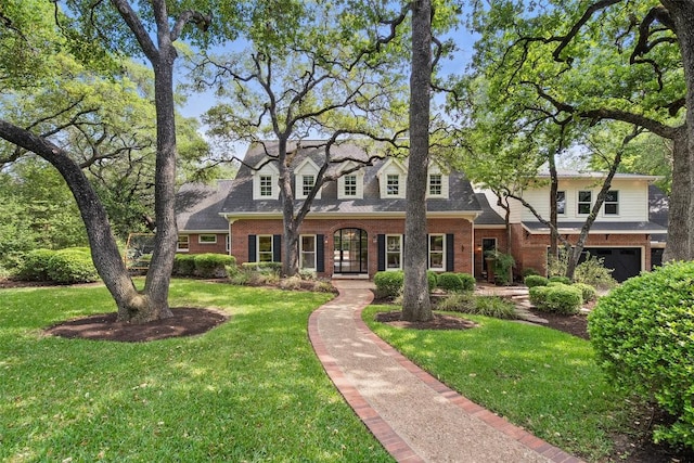 2601 Buckminister Ct, Austin, TX 78746 - cape cod house featuring brick siding, a front lawn, and a garage