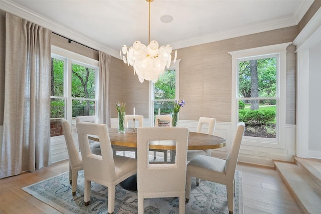 2601 Buckminister Ct, Austin, TX 78746 - dining space with a chandelier, light wood-style floors, ornamental molding, healthy amount of natural light, and a wainscoted wall