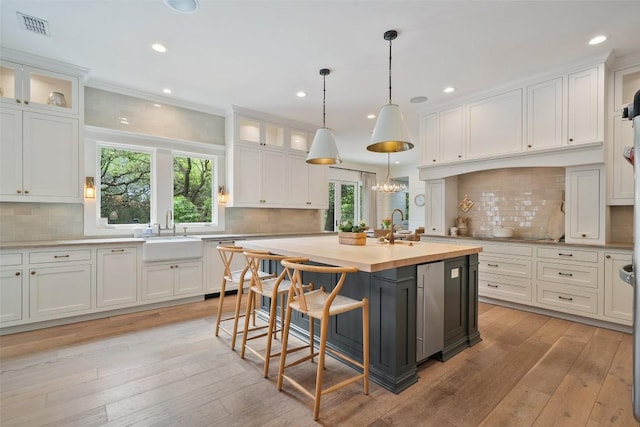 2601 Buckminister Ct, Austin, TX 78746 - kitchen featuring a sink, light countertops, white cabinetry, healthy amount of natural light, and recessed lighting
