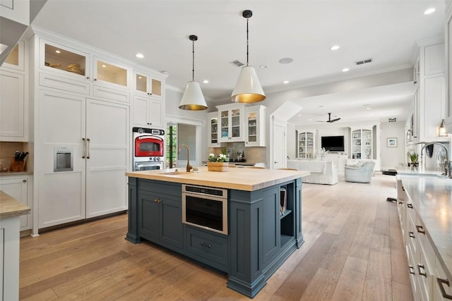 2601 Buckminister Ct, Austin, TX 78746 - kitchen with white cabinets, gray cabinets, open floor plan, a sink, and recessed lighting