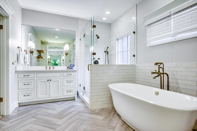 2601 Buckminister Ct, Austin, TX 78746 - bathroom with vanity, a soaking tub, a shower stall, tile walls, and recessed lighting
