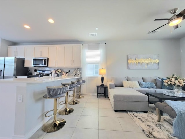 1765 Yaupon Grove Ln, Leander, TX 78641 - living room with light tile patterned flooring, ceiling fan, and recessed lighting