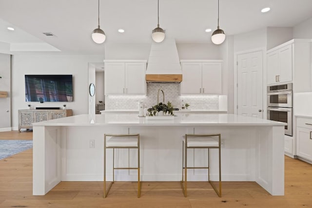 113 Oak Plaza Dr, Georgetown, TX 78628 - kitchen with tasteful backsplash, light countertops, double oven, white cabinetry, and recessed lighting