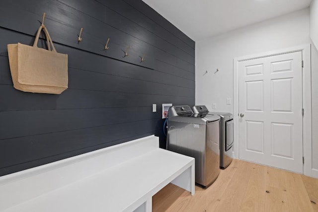 113 Oak Plaza Dr, Georgetown, TX 78628 - washroom featuring independent washer and dryer, light wood-style flooring, and wooden walls