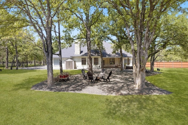 113 Oak Plaza Dr, Georgetown, TX 78628 - rear view of property with a patio, a chimney, an outdoor fire pit, fence, and a lawn