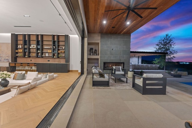4816 Pecan Chase, Austin, TX 78738 - patio terrace at dusk with an outdoor living space with a fireplace and ceiling fan