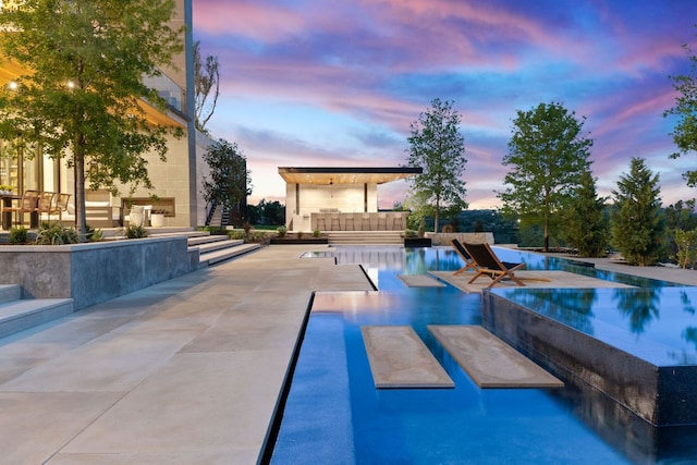 4816 Pecan Chase, Austin, TX 78738 - pool at dusk featuring an infinity pool and a patio