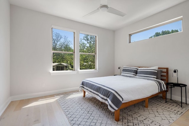 bedroom featuring wood finished floors, baseboards, and ceiling fan