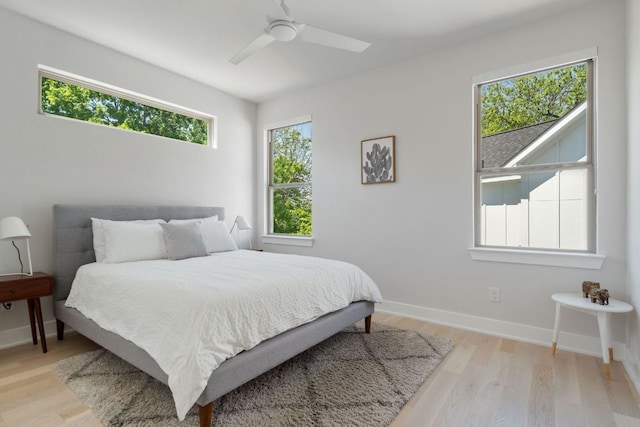 bedroom featuring light wood finished floors, baseboards, and ceiling fan