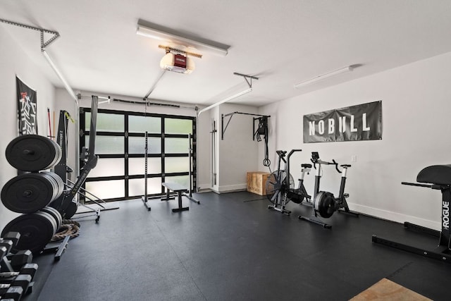 workout room featuring baseboards and a garage